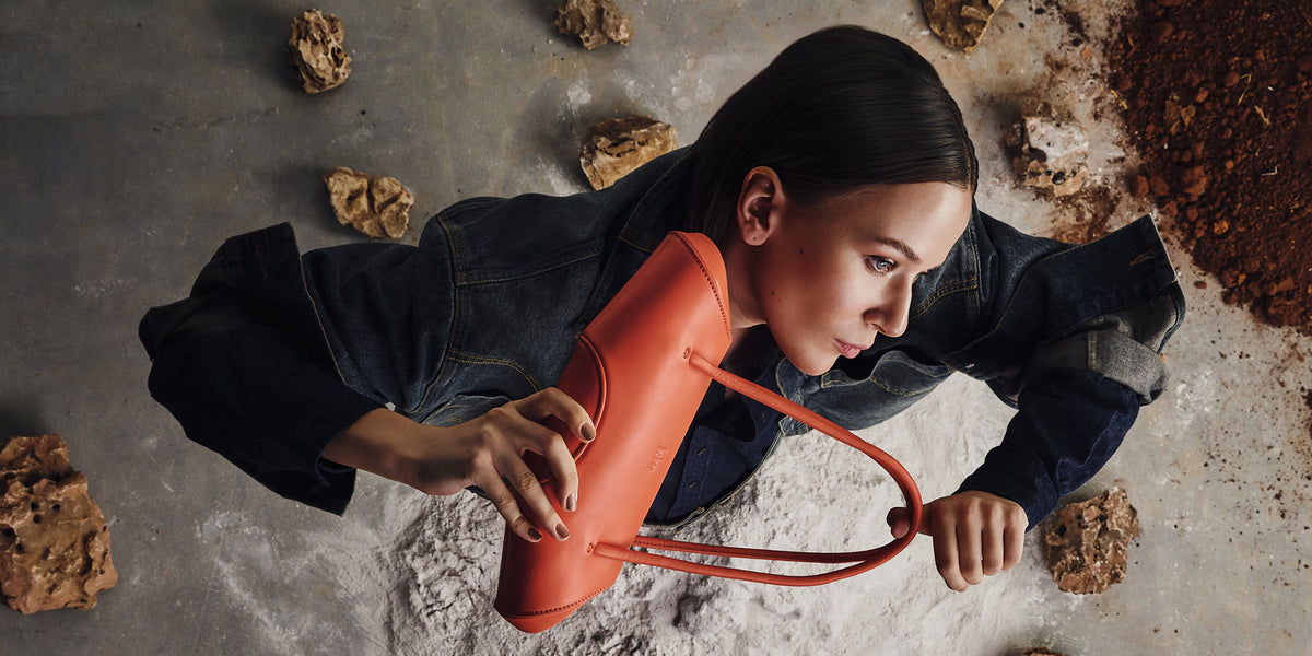 Person holding a red tool on a textured surface